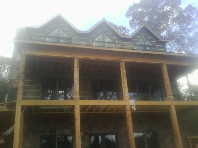 Dormers and porch framing on a large log home under construction — Roof Coating work by our crew in Mattapan
