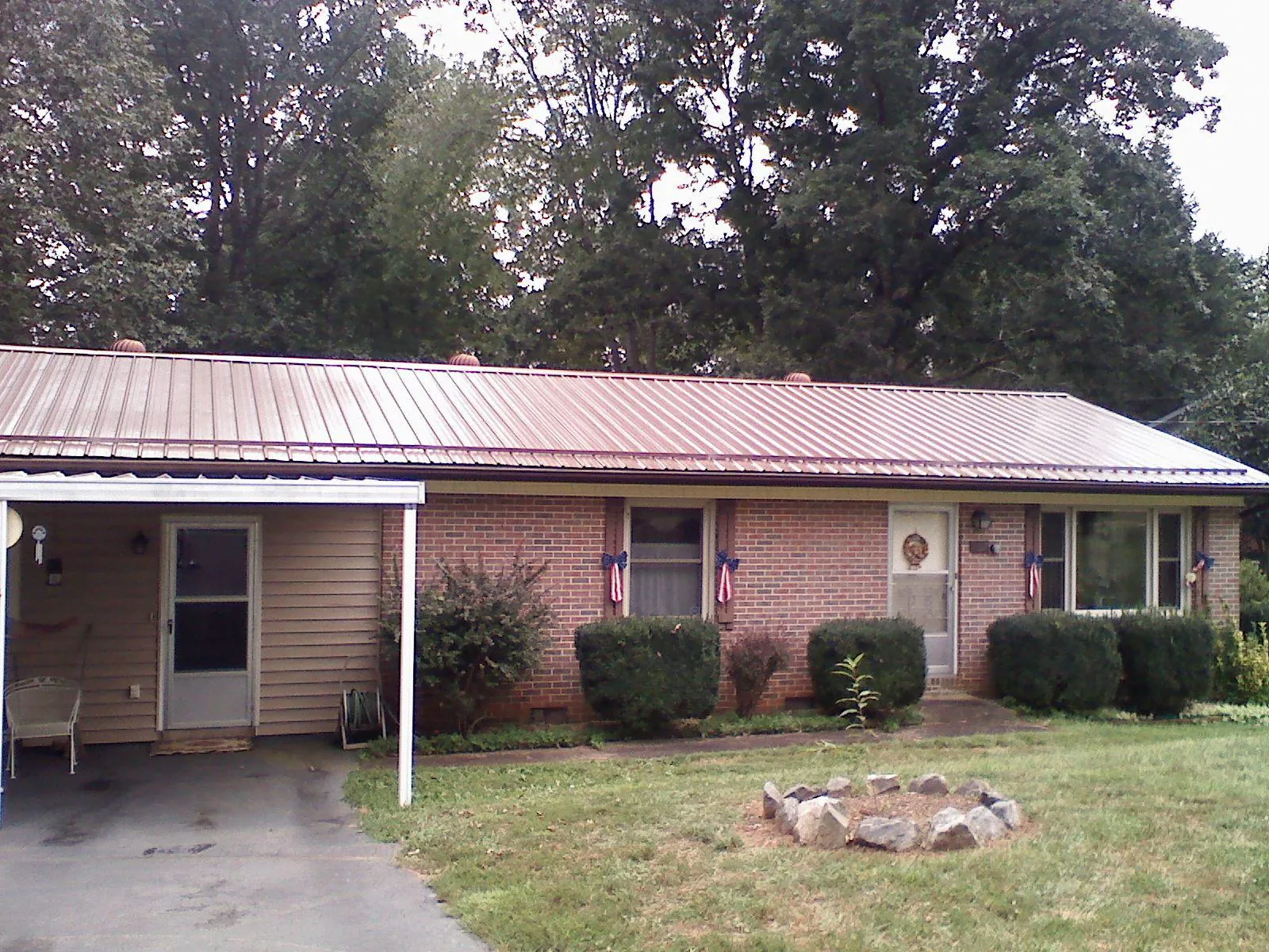 Bronze metal roof and carport on a brick ranch home — Roof Repair work by our crew in Mattapan