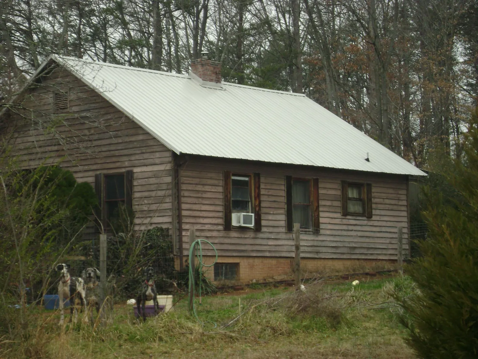 White metal roof on an old wood sided farmhouse, from a Metal Roof Installation job in Mattapan