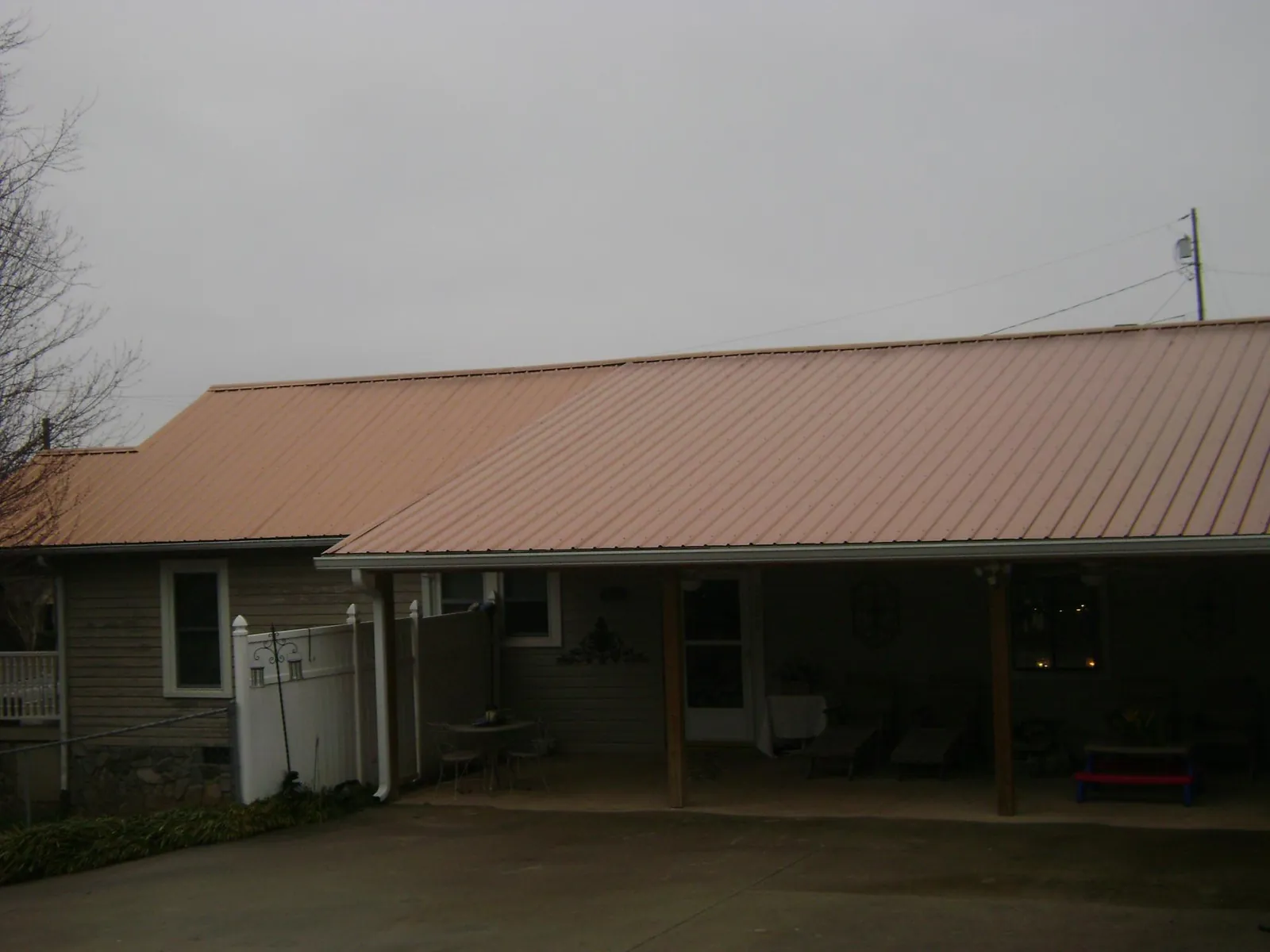Copper toned metal roof over a wide covered patio in Mattapan